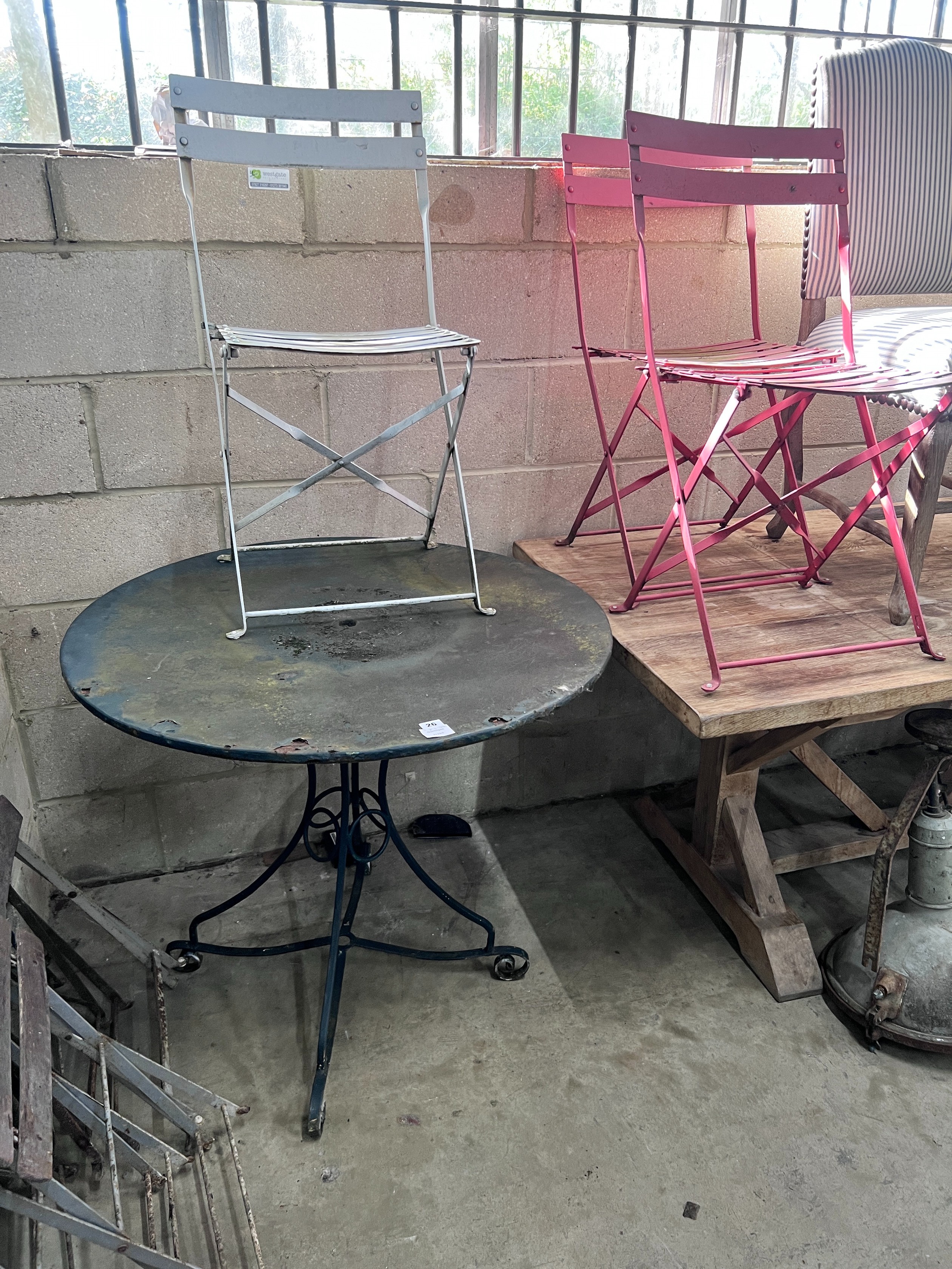 A circular metal and wrought iron garden table, diameter 90cm, and three chairs